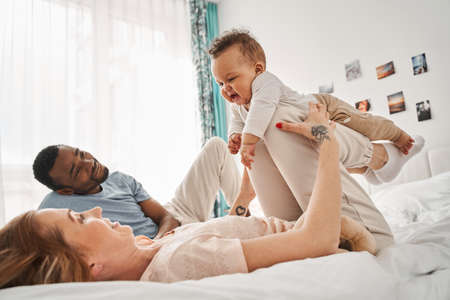 Man looking at his lovely son while his wife holding himの写真素材