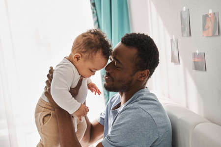 Man looking at his child and touching his baby