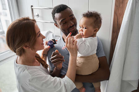 Caucasian woman applying cream at the face of her child