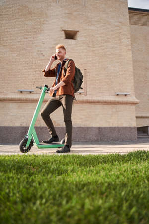 Man spending day outdoors and travelling on powered scooterの写真素材