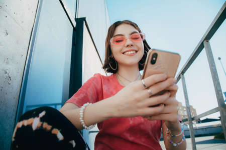 Lady wearing glasses holding mobile phone and smilingの写真素材