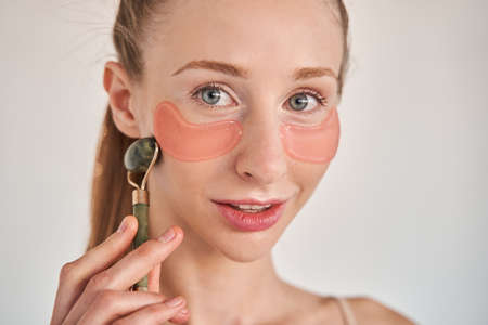 Female with vitiligo skin wearing cosmetic mask under eyes for preventing wrinkles
