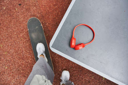 Man standing with one leg at the skate and preparing to taking his headphonesの写真素材