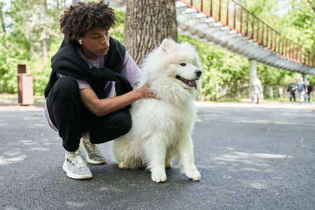 Teen man spending time with his pedigree dog in the summer streetの写真素材