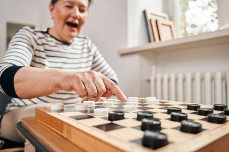 Aged couple playing at the checkers at the nurse houseの写真素材