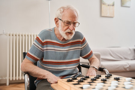 Seniors couple playing checkers at nurse home togetherの写真素材