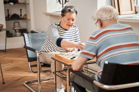 Checkers tournament between senior loving couple at the retirement houseの写真素材