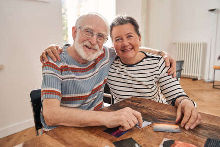 Couple of old people looking at camera and smiling while embracingの写真素材