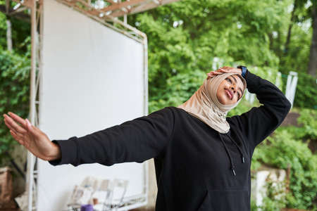 Woman wearing hijab warming up before a morning workout at the spring parkの写真素材