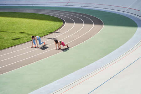 Confident females in starting position ready for running