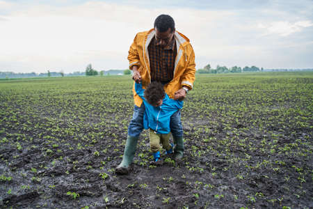 Man holding at the hands his little son while playingの写真素材