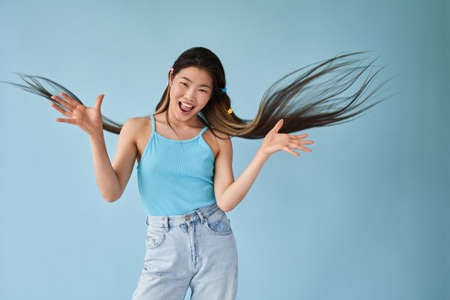 Woman flapping her long brunette hair and posing with open mouth