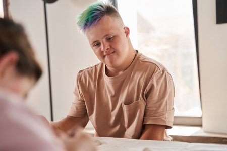 Man with down syndrome sitting at the table and looking at his girlfriend