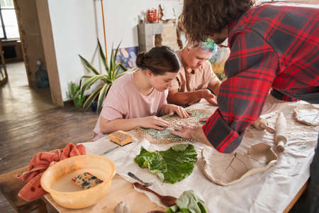 Teacher showing to his students with special needs how to imprint the patternの写真素材