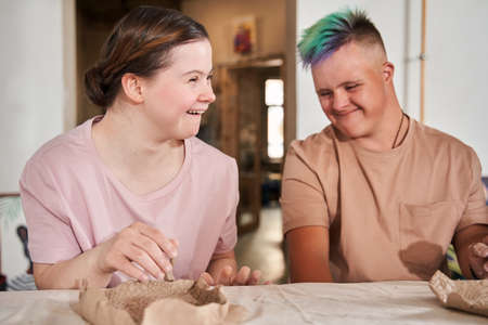 Girl with down syndrome laughing out loud and looking away while enjoyingの写真素材