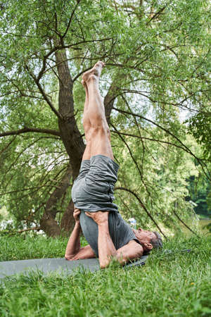 Man keeping his legs up and holding his body with the hands while training