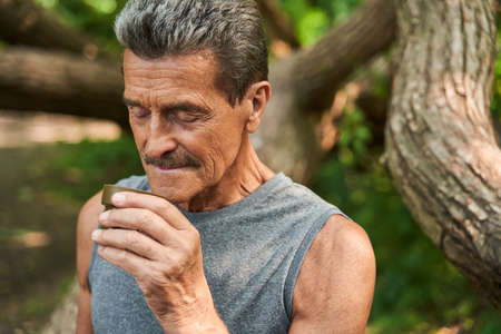 Man standing at the forest and smells aroma of the hot tea from the cup
