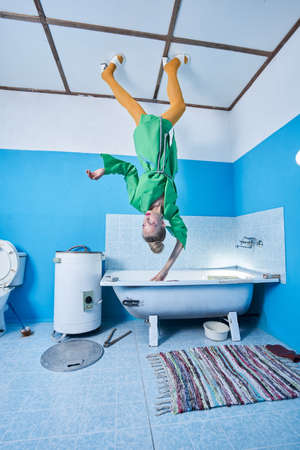 Woman with colorful makeup looking away and holding of the edge of bathtub