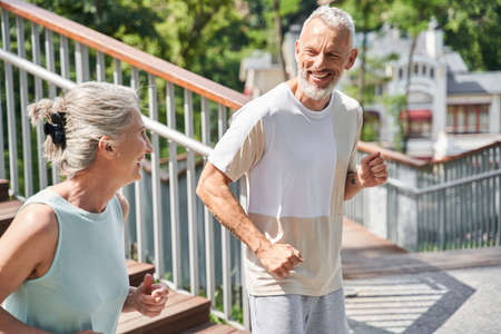 Happy spouses running with each other at the morning and feeling great and satisfied