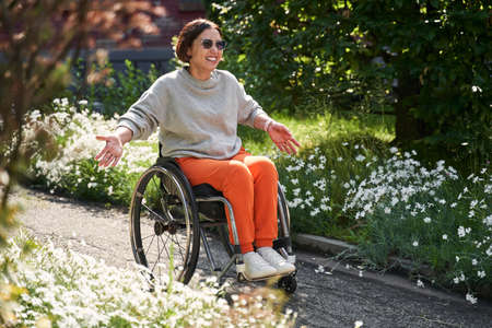 Female person with loss of leg function sitting at the special armchair