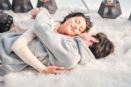 Woman laying at the floor, cuddling her handsome man and closed her eyesの写真素材