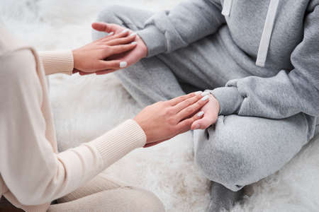 Woman keeping her hands at the hands of her man and feeling happinessの写真素材
