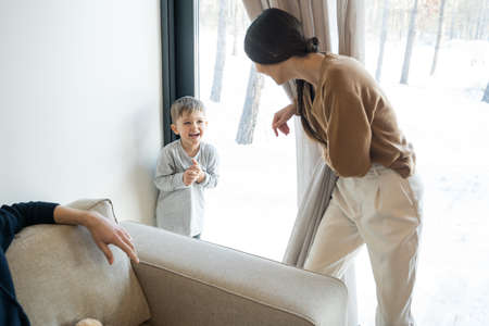 Woman catching son while playing at peekabooの写真素材