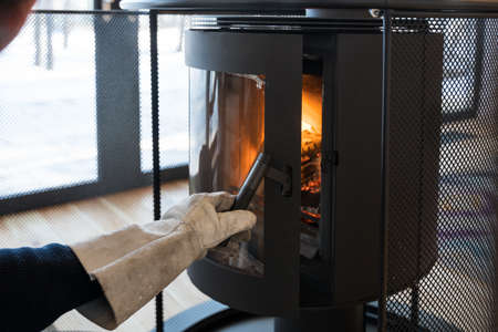 Man opening the door of the fireplaceの写真素材