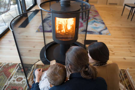 Family with kid relaxing on carpet and cuddlingの写真素材
