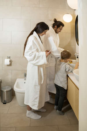 Boy playing with his toy ducks at the sinkの写真素材