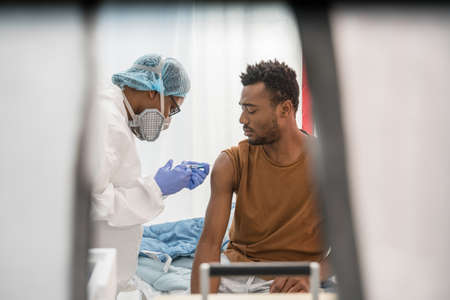 Nurse preparing medical syringe for giving injection