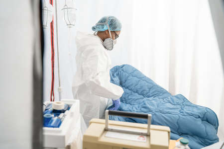 Medical worker making the medical bed and preparing isolation unitの写真素材