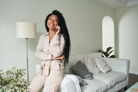 Smiling young black woman talking on mobile phoneの写真素材