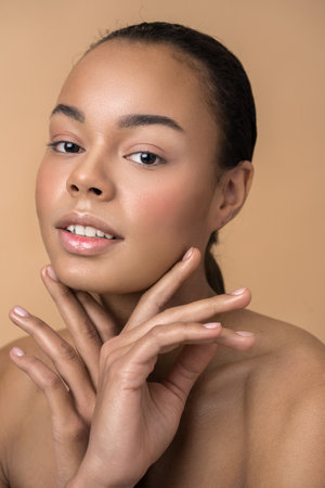 Girl having nude makeup posing with hands near her face