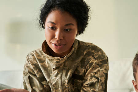 Soldier woman wearing military uniform looking at something with interestの写真素材