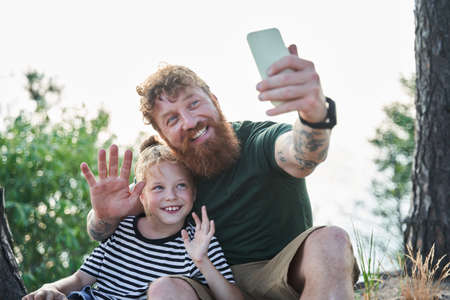 Pleasant father and daughter photographing themselves with gladness smilesの写真素材