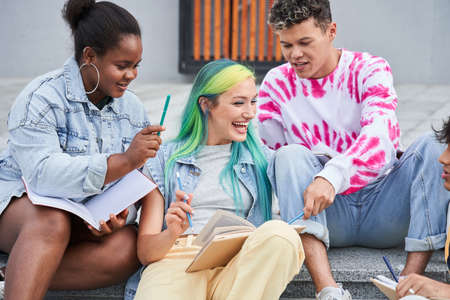 Different races friends doing homework in city