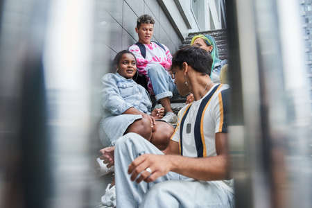Group of friends sitting at the stairs and relaxing after lessons