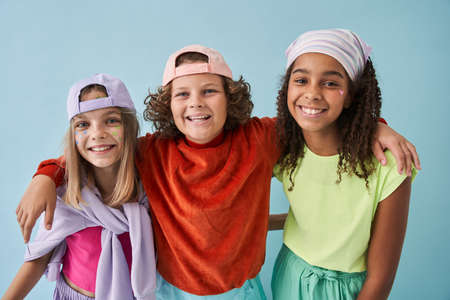 Best friends wearing urban clothes embracing and smiling to the camera