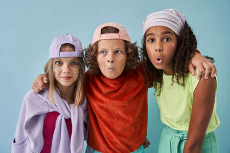 Boy and two teen girls embracing with each other and posing to the cameraの写真素材