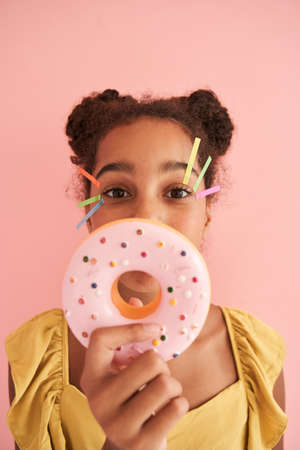 Black girl with stickers on her face showing donutの写真素材