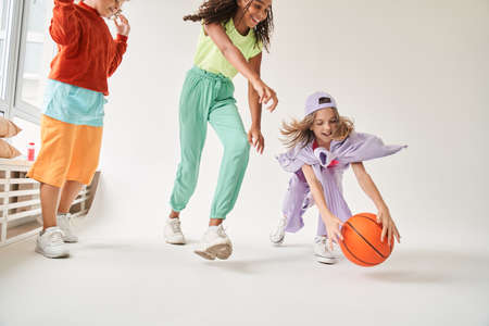 Multiracial friends play basketball game in studio