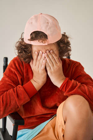 Boy sitting on directors chair and closed his eyesの写真素材