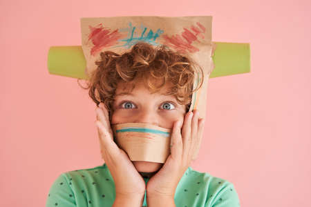 European boy head in painted paper bag with cupsの写真素材