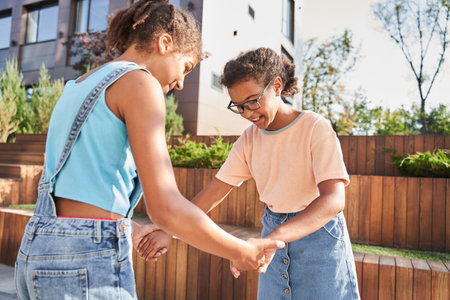 Little girl holding hands of her girlfriendの写真素材