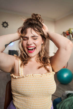 Oversize woman screaming and touching her hairの写真素材