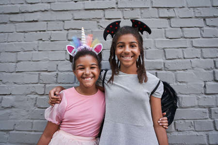 Girls hug at halloween on brick wall backgroundの写真素材