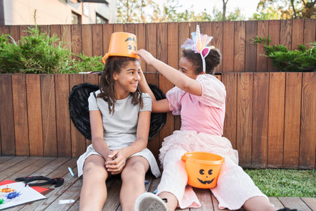 Girl put bucket on head of girlfriend at halloweenの写真素材