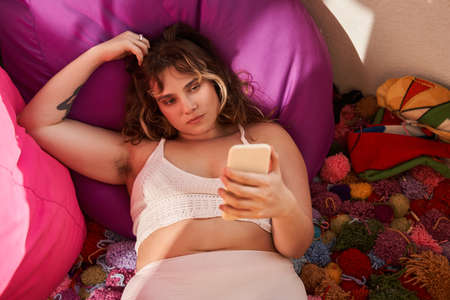 Oversize woman watch something on mobile phoneの写真素材