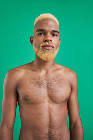 Blonde hair looking directly at the camera and smiling light while posingの写真素材